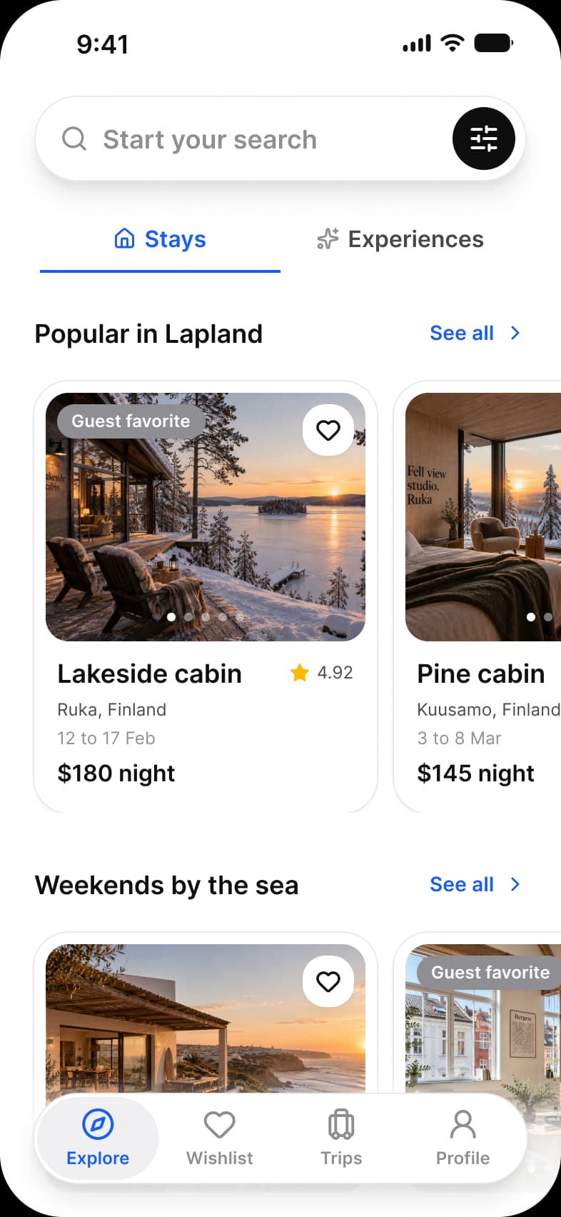 Booking app Explore screen: a Start your search capsule with a filter button, Stays and Experiences tabs, Popular in Lapland and Weekends by the sea rows of cabin cards with a favorite heart, rating and price per night, and a floating tab bar